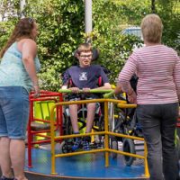Young person on a wheelchair accessible roundabout