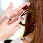 Close up of brown hair being cut with scissors